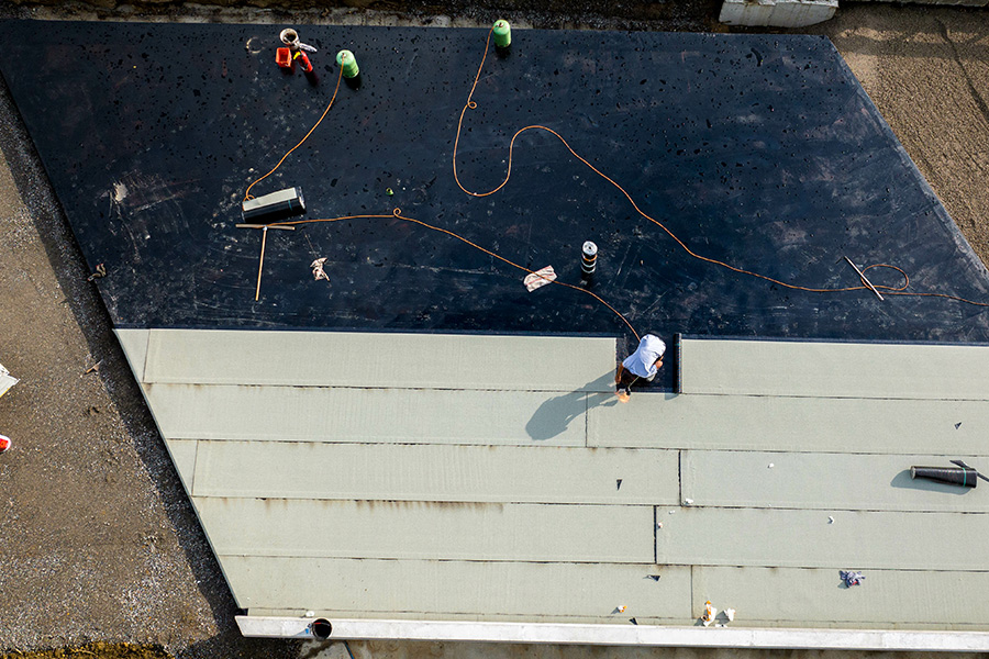 Travaux d’étanchéité de toiture par Etancheite Em Aquitaine à bordeaux avec membrane noire et panneaux gris