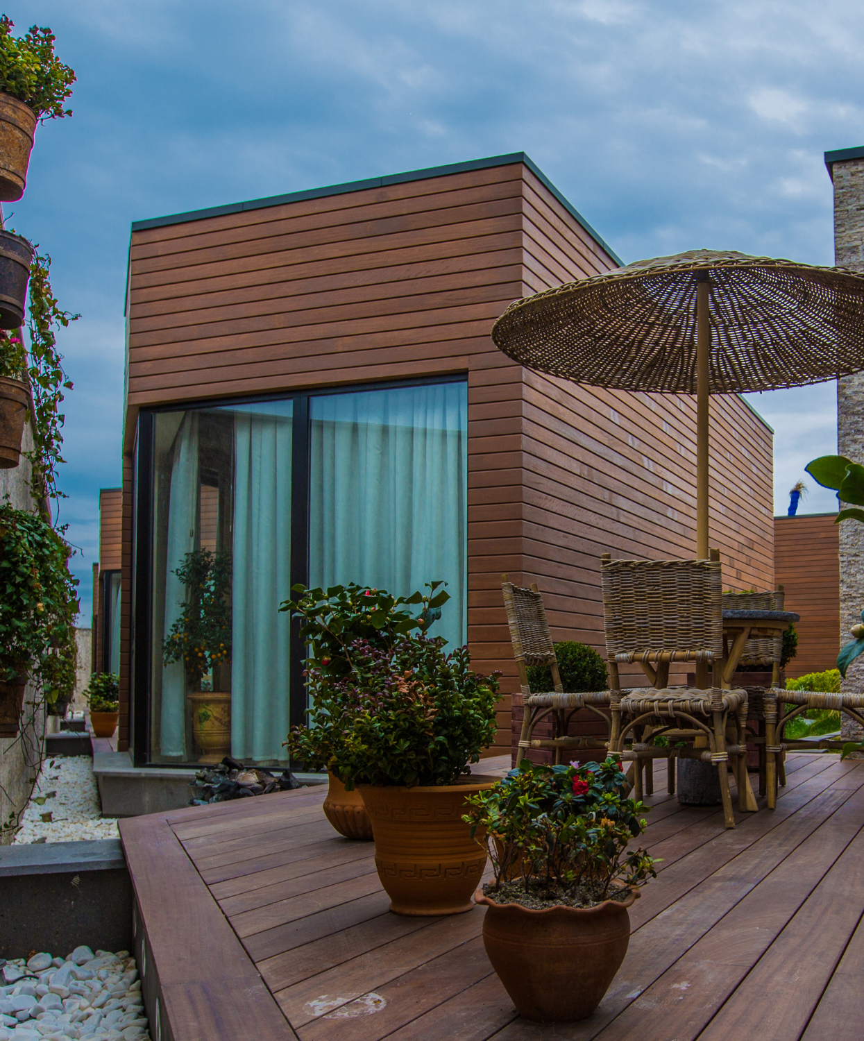 Terrasse bois moderne aménagée avec mobilier rotin et murs végétalisés par Etancheite Em Aquitaine à bordeaux