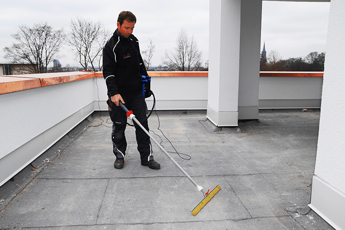 Technicien Etancheite Em Aquitaine nettoyant une terrasse plate en toiture à bordeaux